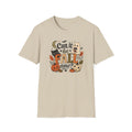 A light beige crewneck t-shirt featuring a colorful graphic print on the front with the text 'Can it be FALL now?' surrounded by autumn and Halloween elements like pumpkins, a ghost, a cat, and leaves.