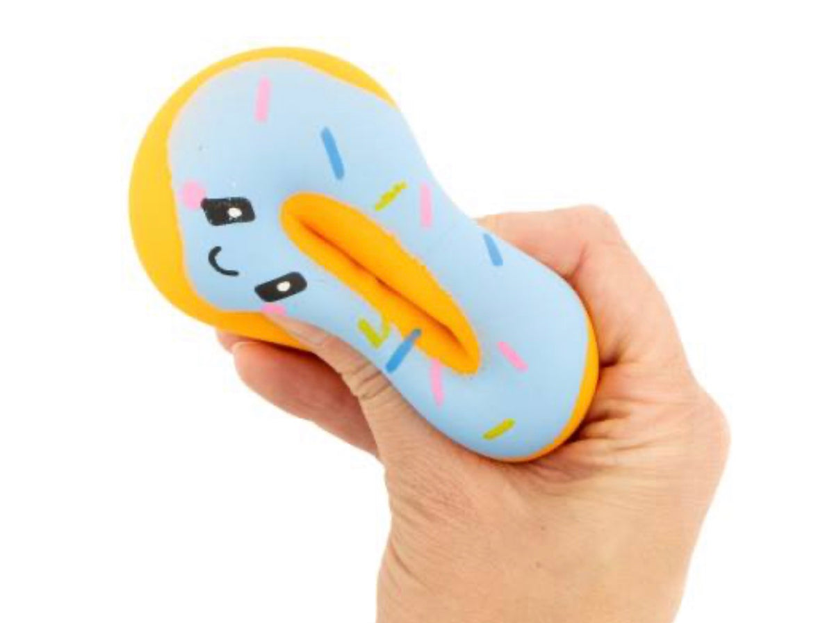 A hand holding a light blue and yellow donut-shaped squishy toy with a cute face and colorful sprinkle details, set against a plain white background.