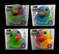 Four Fun Doh SquishZilla Mega Tie-Dye Duck Squishy Toys in clear display boxes, featuring vibrant swirled colors including green, purple, blue, pink, yellow, and orange. These jumbo rubber duck-shaped sensory toys have orange beaks, black eyes, and a soft, squeezable jelly texture.