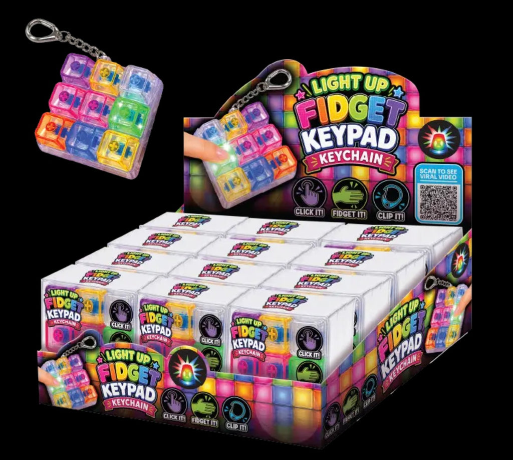 A retail display box filled with small white packages of light-up fidget keychains, plus one larger keychain shown floating above the display. The packaging and product are brightly labeled 'Light Up Fidget Keypad Keychain' with multicolored graphics and icons for click, turn, and glow features.