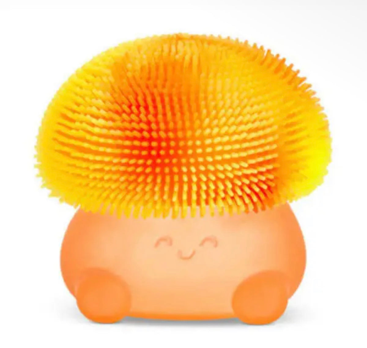 An orange and yellow mushroom-shaped silicone scrubber with a smiling face, shown on a plain white background.
