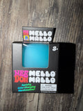 A package of Nee Doh Mello Mallo squishy, color-changing marshmallow toy in a bright turquoise blue color, shown in its original black retail box on a dark wood background.