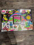A colorful 'Nee Doh Advent' 24-day surprise box set on a dark wood floor, sealed in clear plastic wrap with a hand holding the bottom right corner.