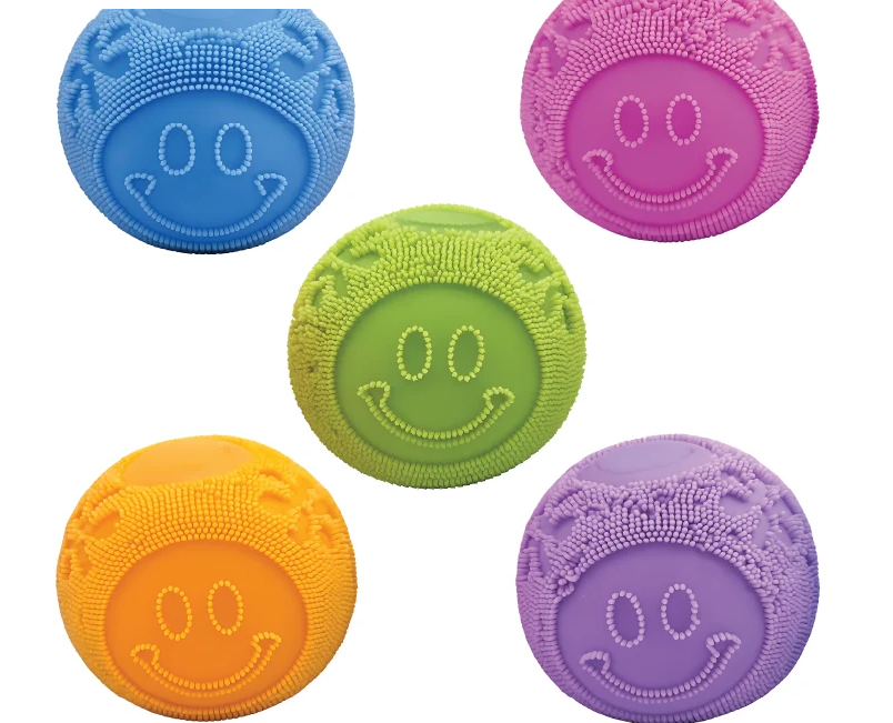 Five textured smiley-face rubber balls in blue, pink, green, orange, and purple, arranged on a plain white background.