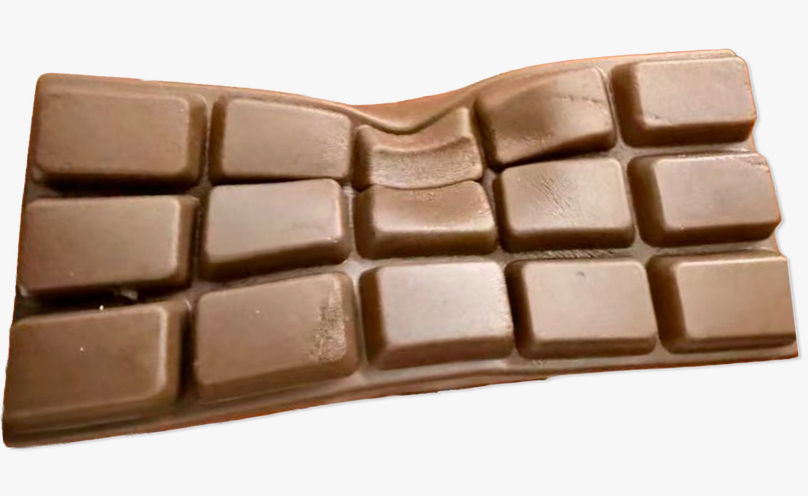 A single chocolate bar with a wavy, undulating shape and a grid of rectangular chocolate pieces, shown on a plain white background.