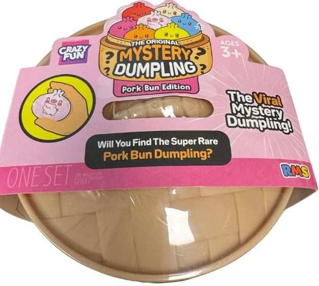 A packaged toy product labeled 'The Original Mystery Dumpling Pork Bun Edition' by Crazy Fun and RKS, showing a round beige dumpling-shaped item under clear plastic with a pink retail hanger card.