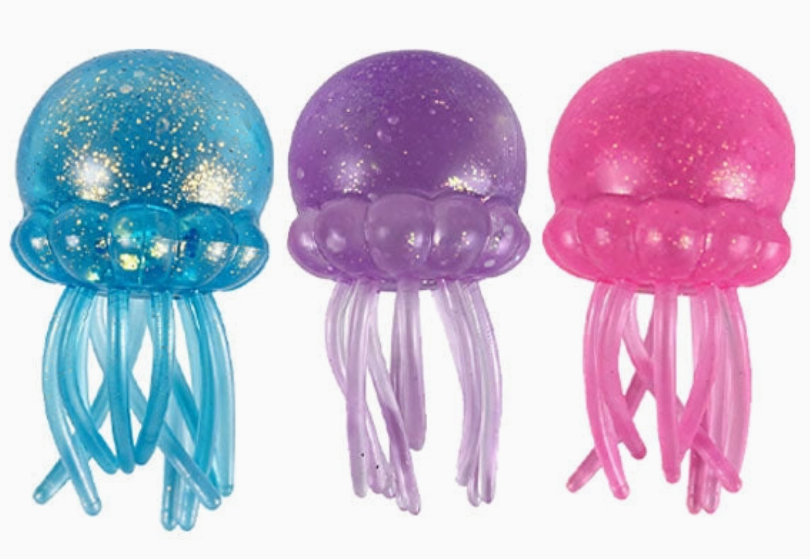 Three translucent jellyfish-shaped items on a white background, shown in blue with gold glitter, purple glitter, and pink glitter.
