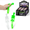 A hand holds a bright green stretchy skeleton toy, with two more skeleton toys shown standing beside a retail display box labeled 'Stretchy Skeleton' on a white background.