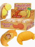 Simulation bread toy set including a croissant and a pineapple-shaped toy, with a hand squeezing a yellow bread-like toy. A display box and individual packages labeled 'Simulation Bread' are shown on a white background.
