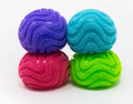 Four textured, ribbed exercise balls in purple, turquoise, pink, and lime green, stacked in a 2x2 grid on a white background.