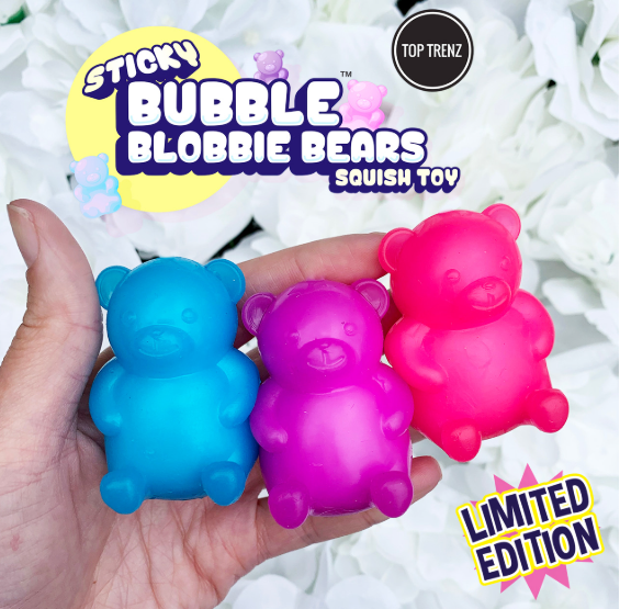 Three squeeze bubble bear toys in blue, purple, and pink are held in a person's hand against a background of white flowers. The image features promotional text overlays including 'STICKY BUBBLE BLOBBIE BEARS', 'TOP TRENZ', and 'LIMITED EDITION'.