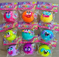 Nine packaged Smushers squishy toys in various bright colors, arranged in a grid on a light wood surface. Each toy is in its original blister packaging with a pink and purple header card.